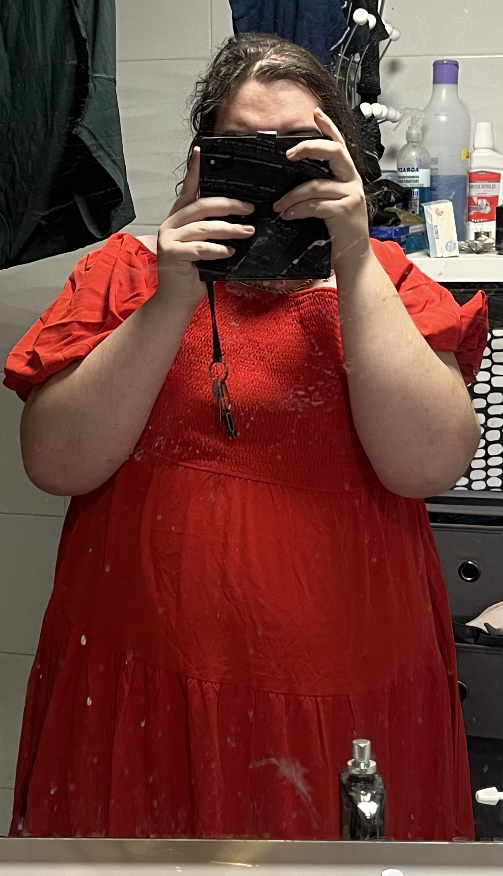 Juan Pedro con un vestido rojo, un 'selfie mirror' delante de un espejo sucio